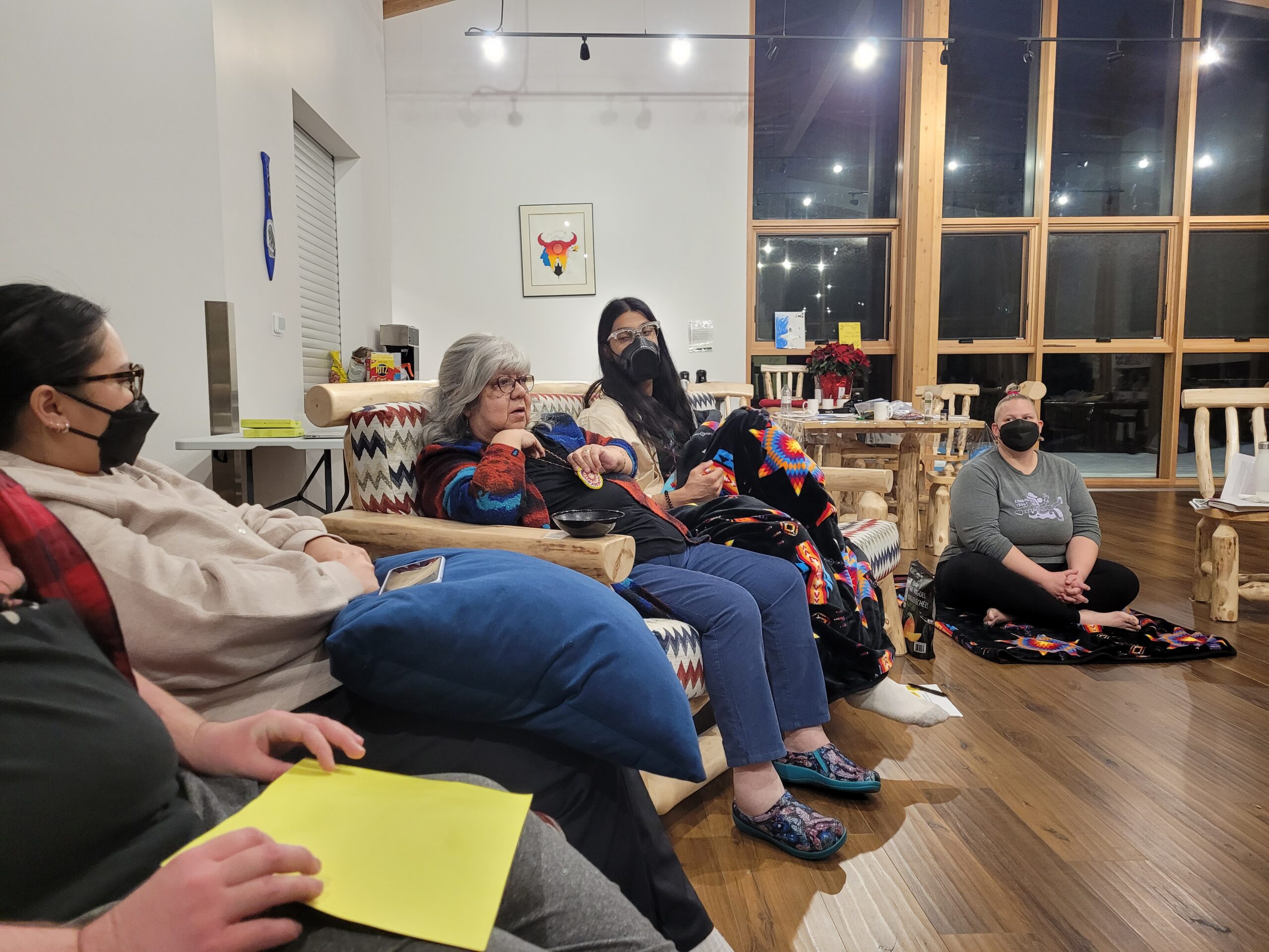 Photo of several participants seated in a semi-circle, engaged in discussion
