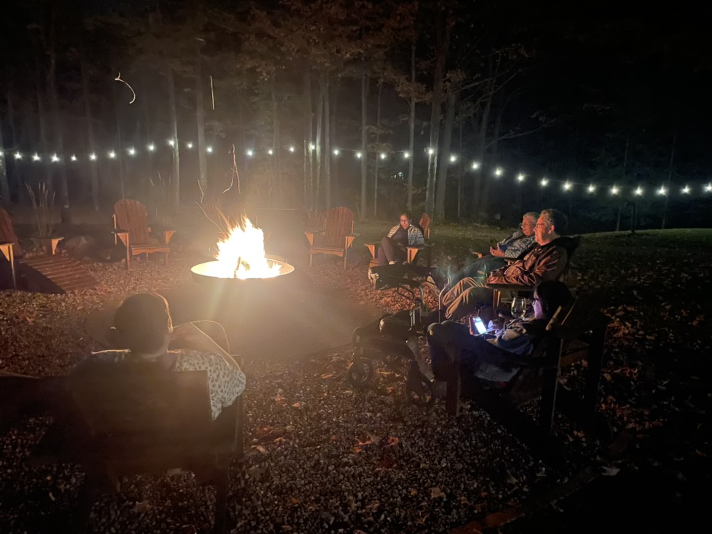 A nighttime photo of people seated around a firepit