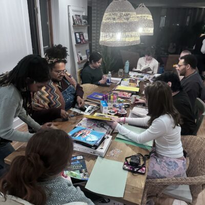 A photo of a group of young people seated around a table working with arts and crafts.
